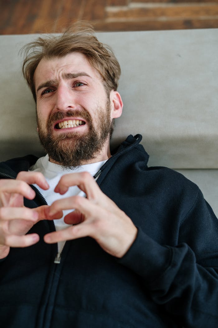 Mastering the First Impression: Your intriguing post title goes here A bearded man exhibiting emotional distress while indoors, capturing a moment of intense feeling.